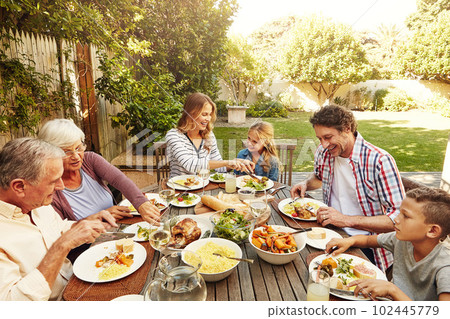 When you share food, you share happiness. a family eating lunch together outdoors. 102445779