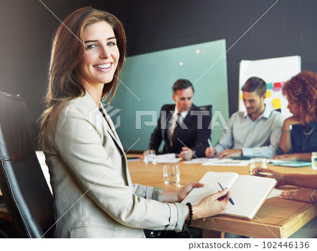 Shes got the right attitude. Portrait of a businesswoman sitting in a meeting with her colleagues blurred in the background. 102446136