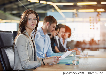 Im focused on being the best. Portrait of a businesswoman sitting in a meeting with her colleagues blurred in the background. 102446154