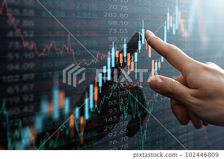 Candlestick charts and financial market data. A hand pointing to a chart. Candlestick charts and financial market data. A hand pointing to a chart. 102446809
