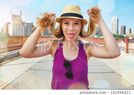 Its a good day for some city fun. a smiling young woman walking around the city in the summertime. 102446811