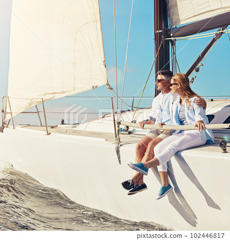 Cruising off to paradise. a couple enjoying a boat cruise out on the ocean. 102446817