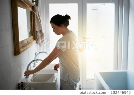 Getting cleaned up. an attractive young woman washing in the bathroom. Getting cleaned up. an attractive young woman washing in the bathroom. 102446943