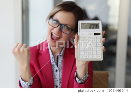 Excited business woman in the office showing one million number on calculator Excited business woman in the office showing one million number on calculator 102446944