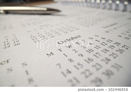 Spiral calendar and pen lying on table Spiral calendar and pen lying on table 102446958