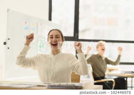 Happy team of managers raising hands up and celebrating victory in office 102446978
