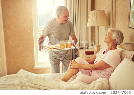 Starting the day off perfectly. a senior man bringing breakfast in bed to his wife. 102447066