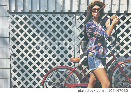 Enjoying a refreshing day out. Portrait of a beautiful young woman riding her bike in the park. Enjoying a refreshing day out. Portrait of a beautiful young woman riding her bike in the park. 102447080