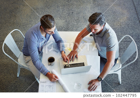 Mapping out their company goals using technology. two colleagues using a laptop in a meeting at the office. 102447795