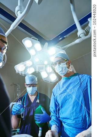 Operating to save you. surgeons in an operating room. 102448020