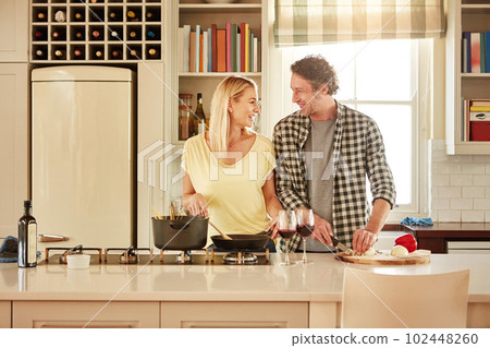 We make a mean team in the kitchen. a couple cooking a meal together at home. 102448260