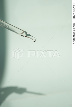 Natural medicine, cosmetic research. The concept of skin care and its analysis. Dermatology. With space to copy. Laboratory pipette with a drop of serum, oil, cosmetics. High quality photo 102448299