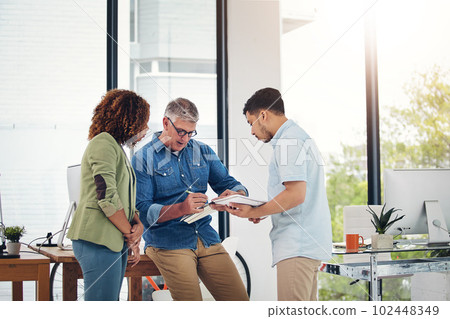 Look how I do it. a creative entrepreneur offering advice to two new colleagues in the office. 102448349