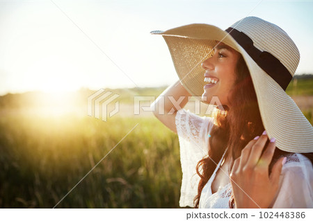 At one with nature. an attractive young woman standing outside in a field. At one with nature. an attractive young woman standing outside in a field. 102448386