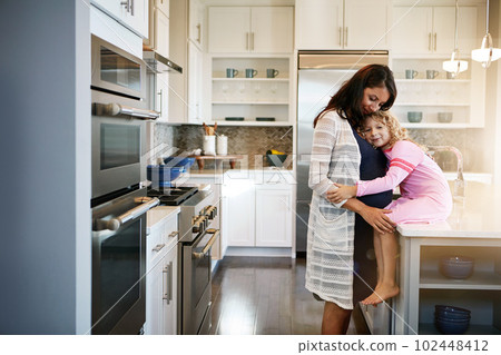 The best comfort comes from a mother. a pregnant woman bonding with her little daughter at home. The best comfort comes from a mother. a pregnant woman bonding with her little daughter at home. 102448412