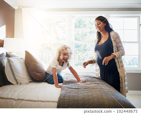 When the baby comes, itll be extra fun. a pregnant woman bonding with her little son at home. 102448675