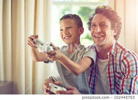 Let your father show you how its done. a father and his son playing video games at home. 102448703