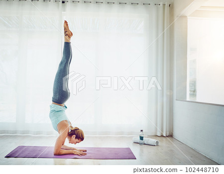 Yoga is a way to freedom. an attractive woman practising her yoga routine at home. 102448710