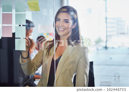First conceptualize success then create it. a businesswoman arranging sticky notes on a glass wall during a brainstorming session. First conceptualize success then create it. a businesswoman arranging sticky notes on a glass wall during a brainstorming session. 102448733