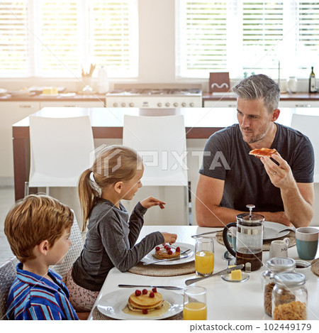 Hes a hands-on dad. a family having breakfast together. Hes a hands-on dad. a family having breakfast together. 102449179