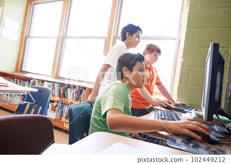 Using computers from an early age have several advantages. elementary children working on computers at school. 102449212