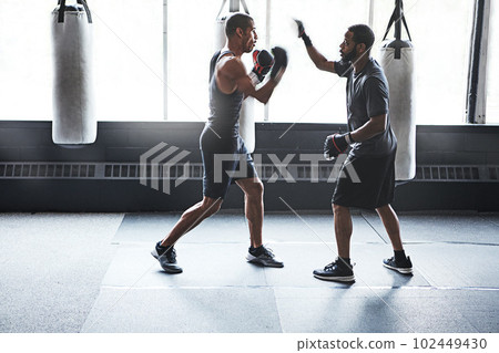 Everyone you meet has something to teach. a male boxer practising his moves with his coach. Everyone you meet has something to teach. a male boxer practising his moves with his coach. 102449430