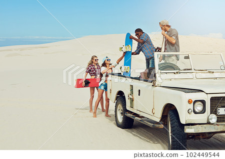 Ready for a fun day of sand boarding. a group of young friends going on a sand boarding road trip in the desert. 102449544