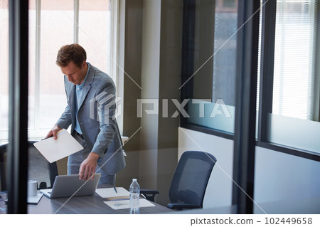 Getting his documents in order. a businessman looking at paperwork in his office. Getting his documents in order. a businessman looking at paperwork in his office. 102449658