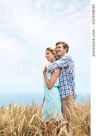 Looking towards their future. a young couple in a field on a sunny day. Looking towards their future. a young couple in a field on a sunny day. 102449690