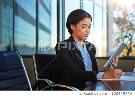 Now she can conduct her work duties with ease. a businesswoman taking notes while using her tablet. 102449749