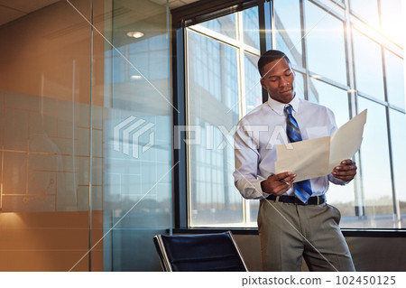 Nothing feels better than succeeding. a young male lawyer standing by his desk in the office. 102450125