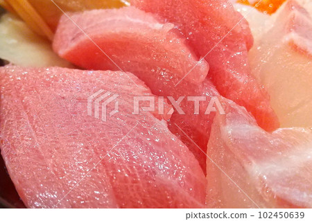 Bowl of rice topped with sashimi  102450639