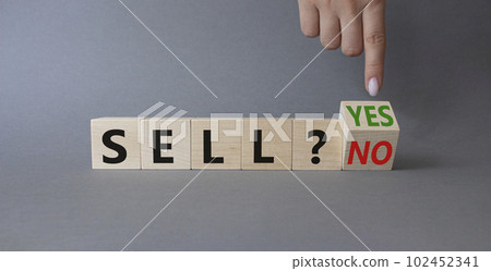 Sell Yes or No symbol. Businessman Hand points at wooden cubes with words Sell No or Sell Yes. Beautiful grey background. Business and Sell concept. Copy space 102452341