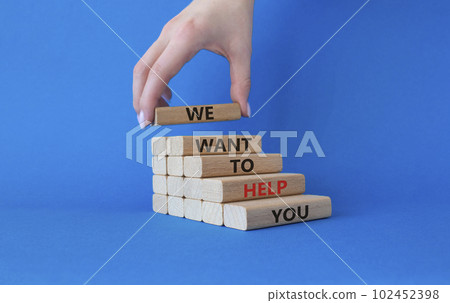 We want to help you symbol. Wooden blocks with words We want to help you. Beautiful blue background. Businessman hand. Business and We want to help you concept. Copy space. 102452398