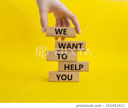 We want to help you symbol. Wooden blocks with words We want to help you. Beautiful yellow background. Businessman hand. Business and We want to help you concept. Copy space. 102452411