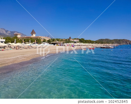 Deck chairs on the beach with umbrellas and loungers with mountains 102452845