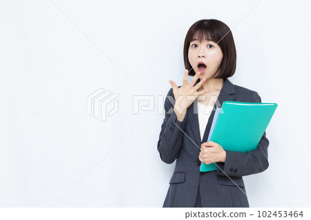 一位穿著西裝的三十多歲的女人在白色背景前感到驚訝 一位穿著西裝的三十多歲的女人在白色背景前感到驚訝 102453464