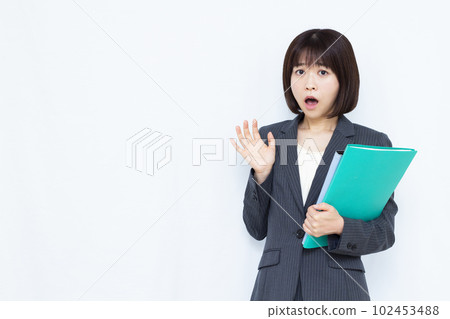 一位穿著西裝的三十多歲的女人在白色背景前感到驚訝 一位穿著西裝的三十多歲的女人在白色背景前感到驚訝 102453488