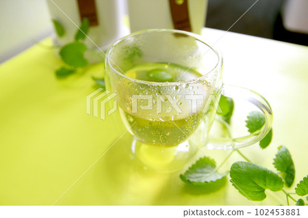 Herbal tea and scented candle concept on yellow background for healthy life and relaxation 102453881