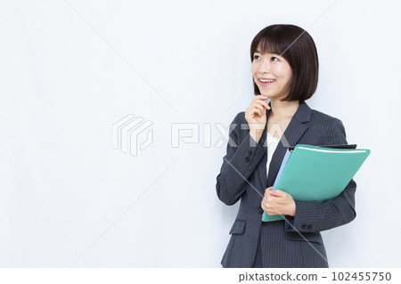 A woman in her thirties in a suit thinking with a smile in front of a white background A woman in her thirties in a suit thinking with a smile in front of a white background 102455750