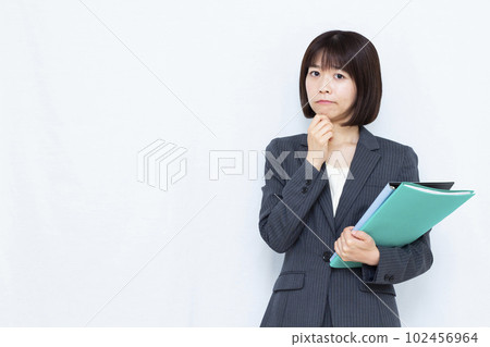 一位三十多歲的西裝女性在白色背景前憂心忡忡 102456964