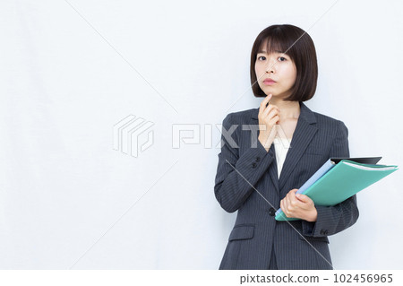 一位三十多歲的西裝女性在白色背景前憂心忡忡 102456965