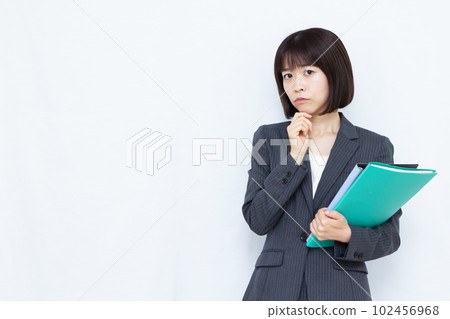 一位三十多歲的西裝女性在白色背景前憂心忡忡 102456968