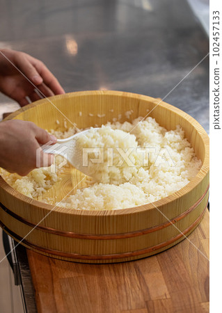 Chef cooking japanese sushi rice in wooden bowl Chef cooking japanese sushi rice in wooden bowl 102457133
