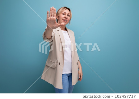 well-groomed neat business woman in a beige jacket on a studio background 102457737