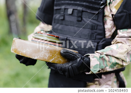 A man in a special suit works with a detector and found an explosive device. A man tries to neutralize an anti-tank mine 102458493