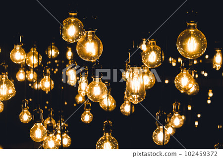 vintage, retro, old fashioned yellow and orange light bulbs hanging on wires 102459372