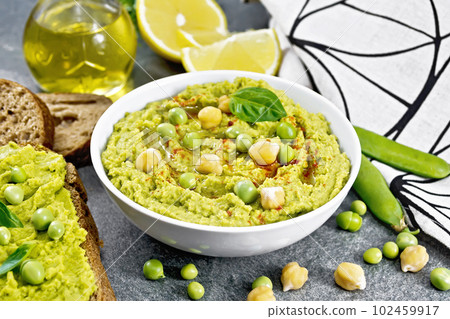 Hummus from green peas in bowl on stone table Hummus from green peas in bowl on stone table 102459917