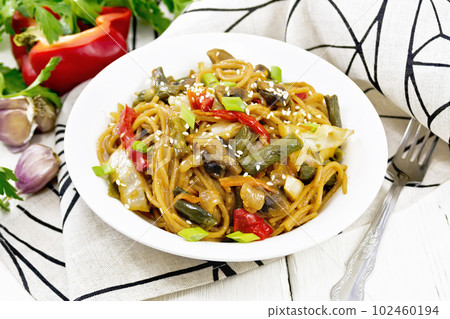 Spaghetti buckwheat with vegetables in plate on light board Spaghetti buckwheat with vegetables in plate on light board 102460194