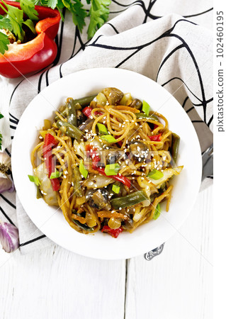 Spaghetti buckwheat with vegetables in plate on light board top Spaghetti buckwheat with vegetables in plate on light board top 102460195